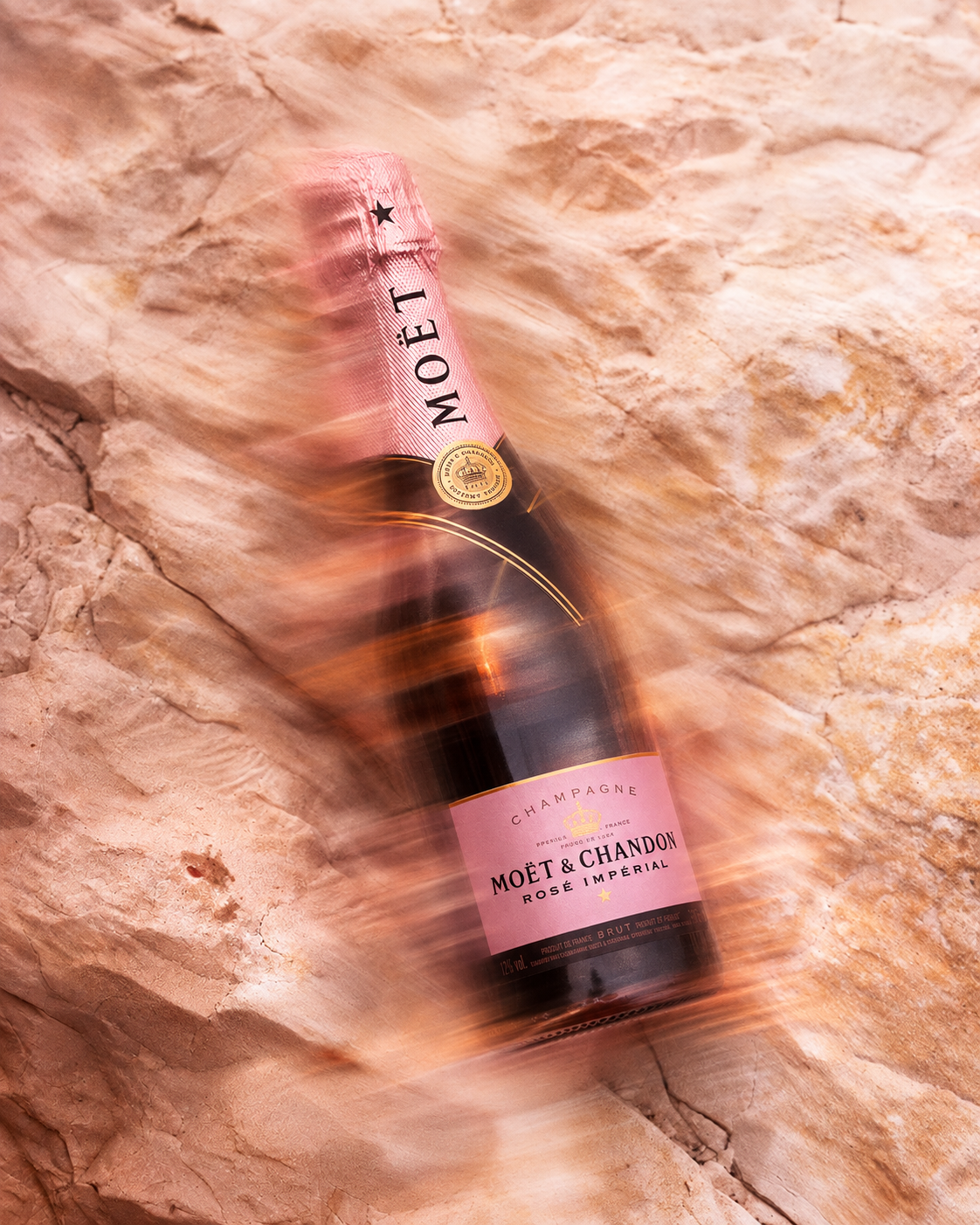 Création visuelle champagne de luxe : Moët & Chandon Rosé Impérial sur fond rocheux
