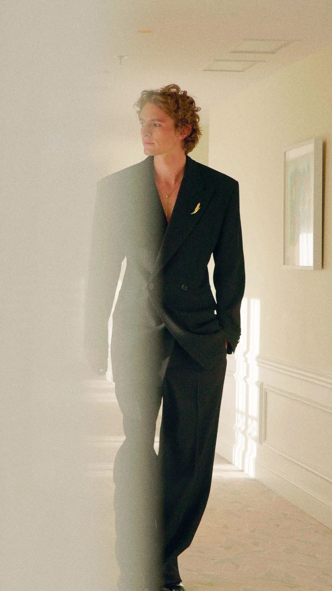 Brand content mode luxe : homme en costume noir dans un couloir lumineux